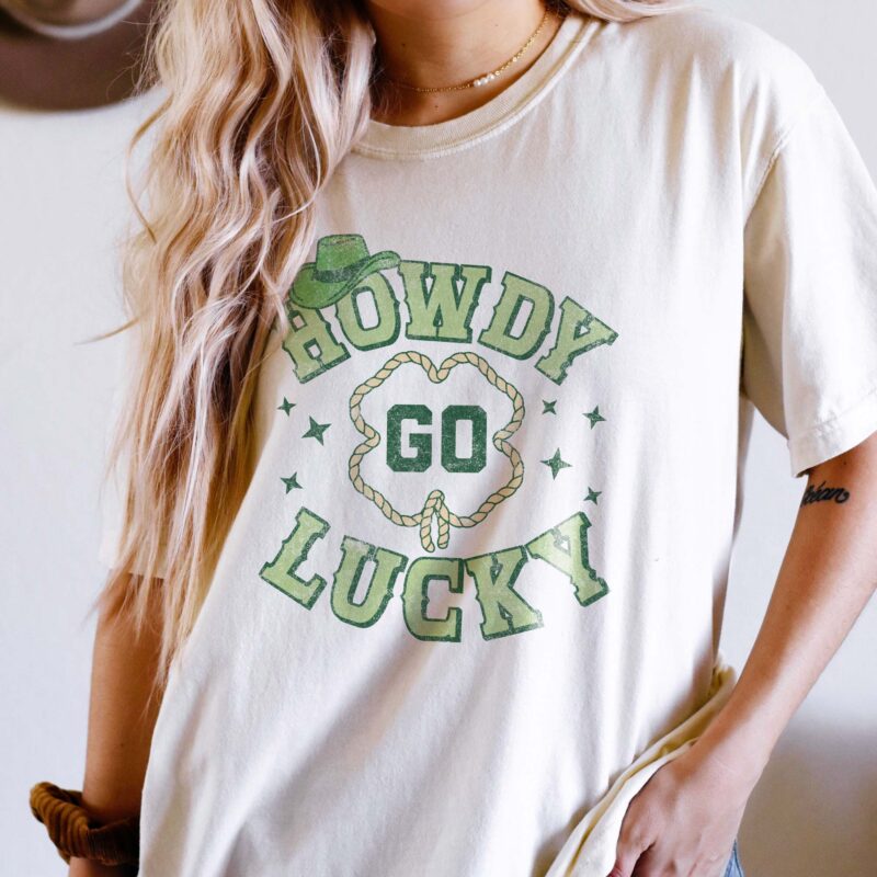 a woman wearing a howdy go lucky cowgirl tee in ivory