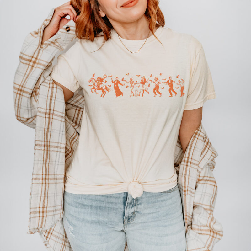 a woman wearing a Halloween Parade Comfort Colors tee in natural