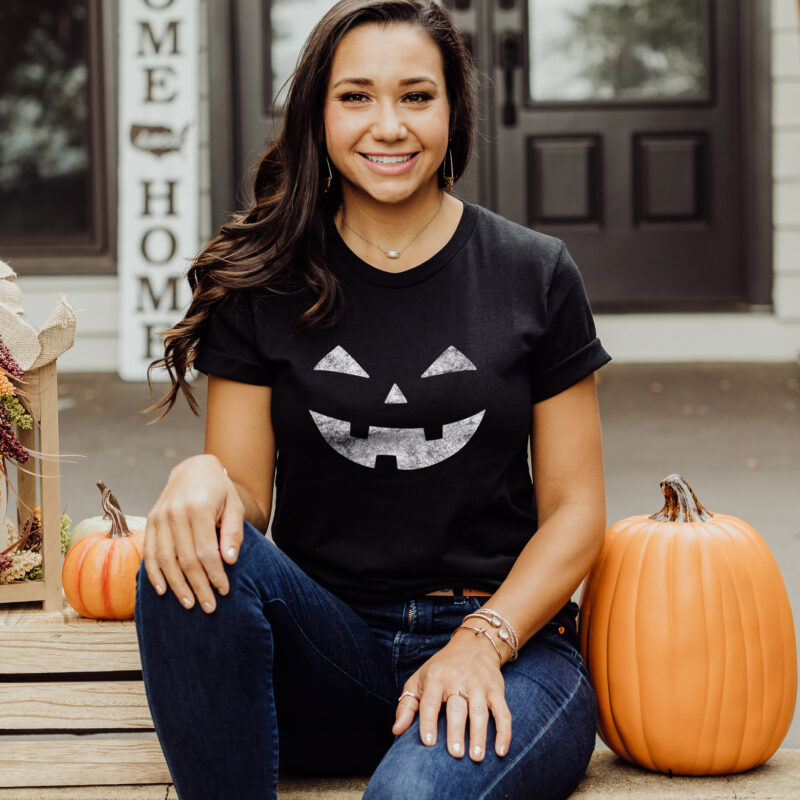 A woman wearing a Laughing Jack-o-lantern tee in black