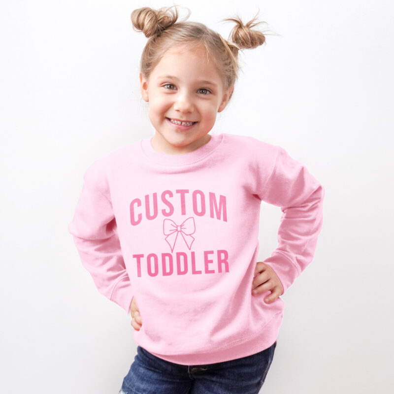 a little girl wearing a custom toddler sweatshirt in pink