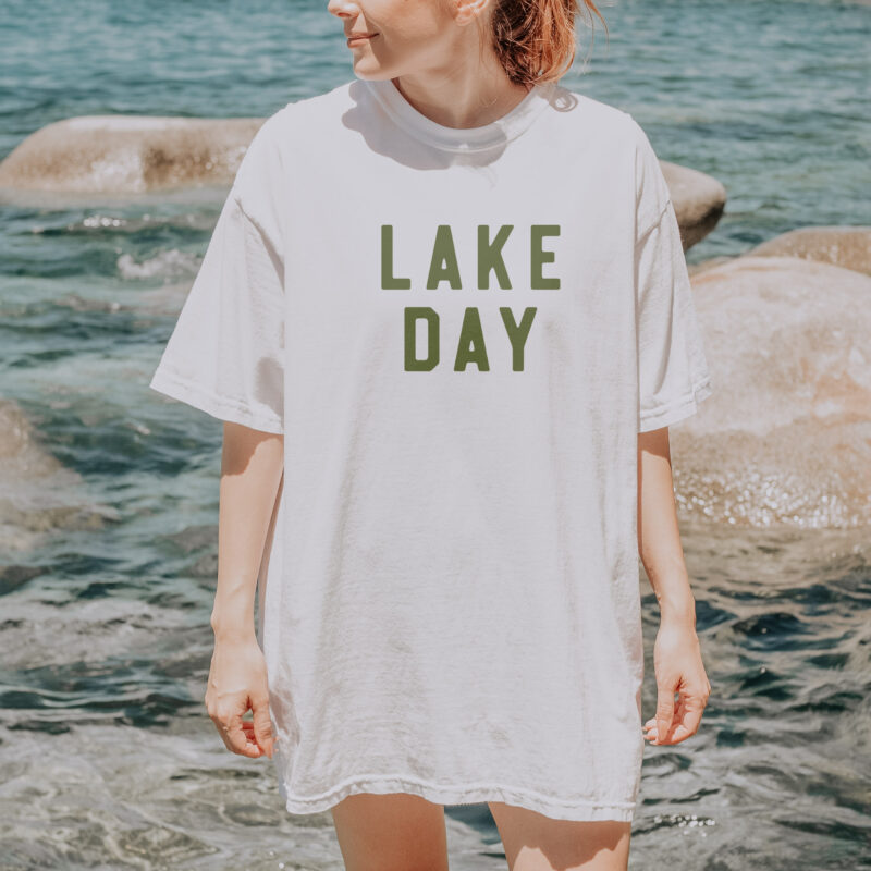 a woman wearing a lake day comfort colors varsity tee in white