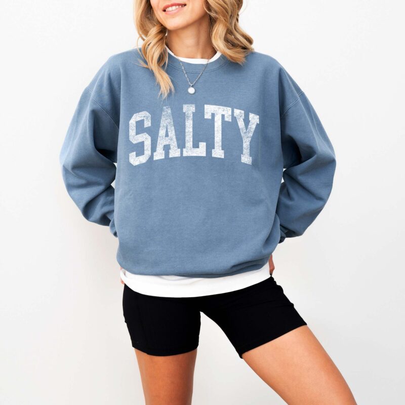 a woman wearing a salty sweatshirt in blue jean