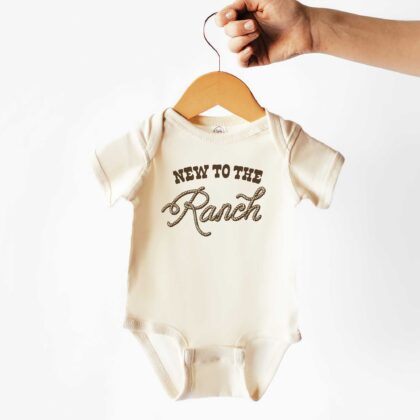 a New To The Ranch Baby Rib Bodysuit in natural