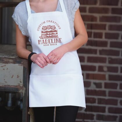a woman wearing a Short Bib XL Personalized Cake Apron in white