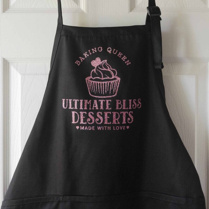 a cupcake baking apron in black