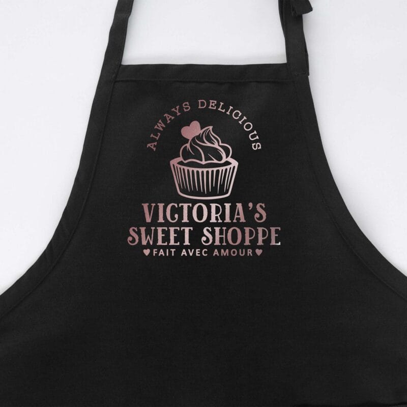 a cupcake baking apron in black