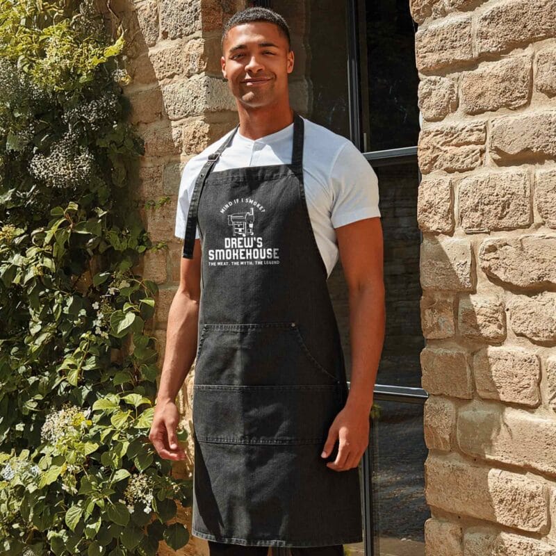 a man wearing a Personalized Denim Smoker Apron in black denim