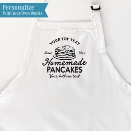 Pancake Maker Apron personalization guide showing custom top text, a year beside the pancake graphic, fixed Homemade Pancakes wording, and custom bottom text.