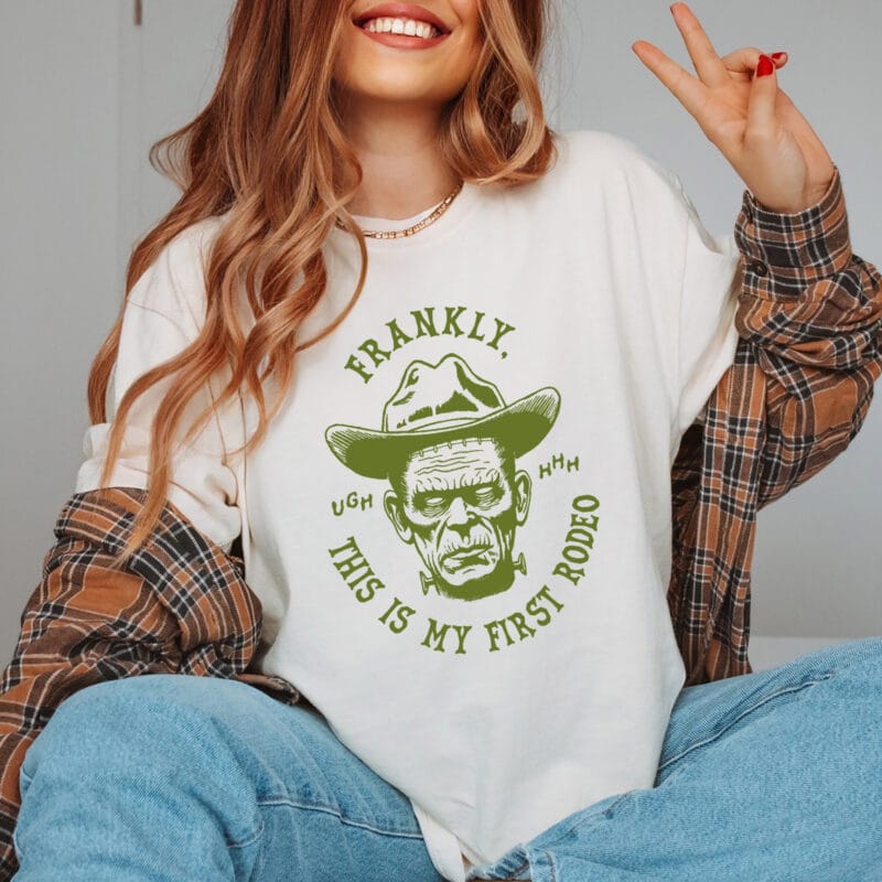 a woman wearing a first rodeo halloween tee in ivory