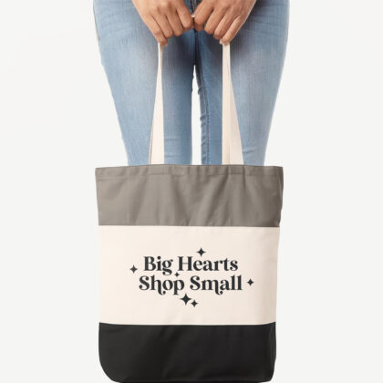 a woman holding a big hearts shop small tote bag in black