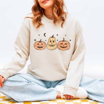 a young woman wearing a Jack-O-Lanterns Halloween Sweatshirt in sand