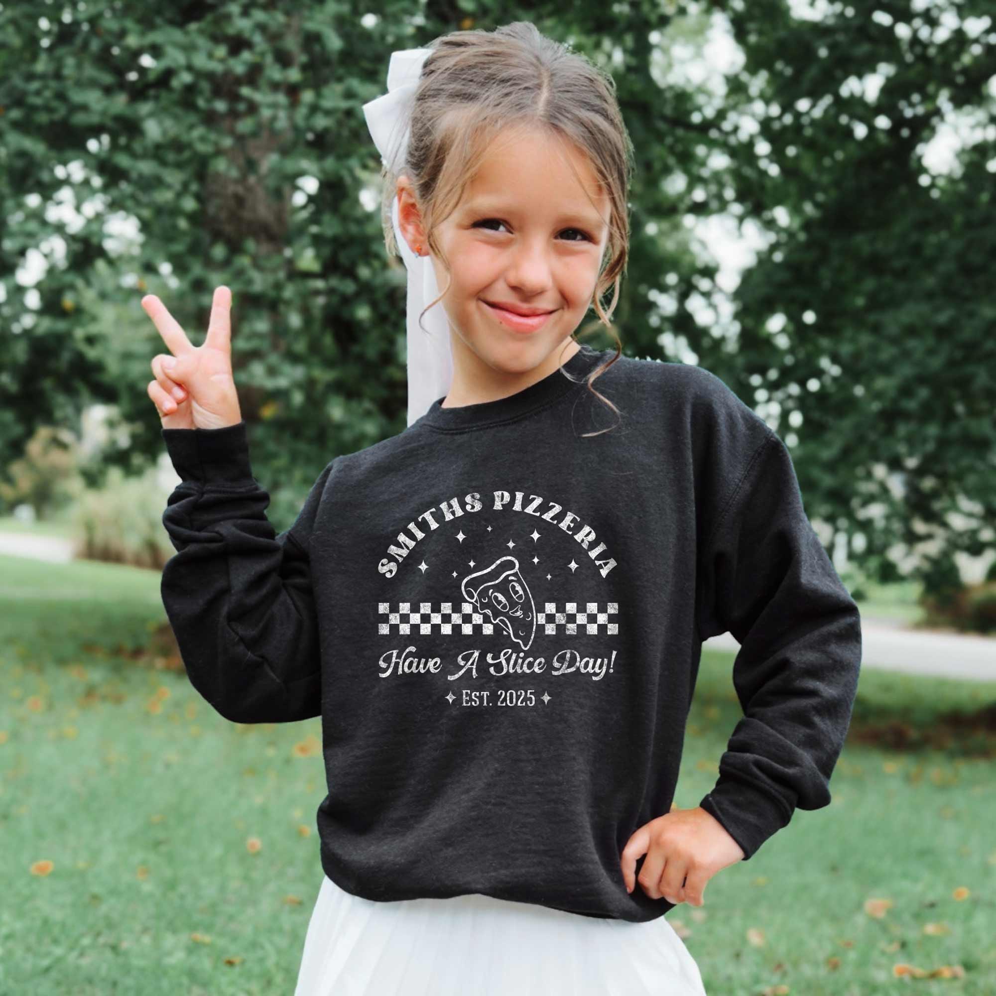 a little girl wearing a Kids Retro Pizza Sweatshirt in black