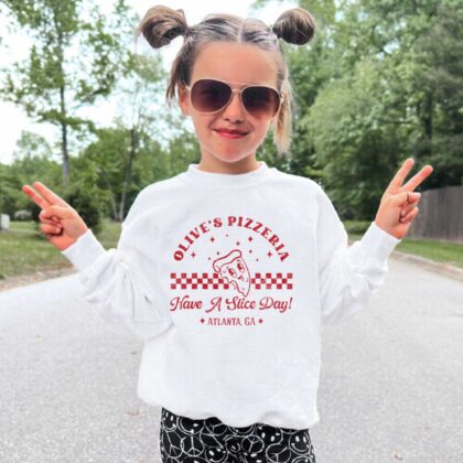 a little girl wearing a Kids Retro Pizza Sweatshirt in white