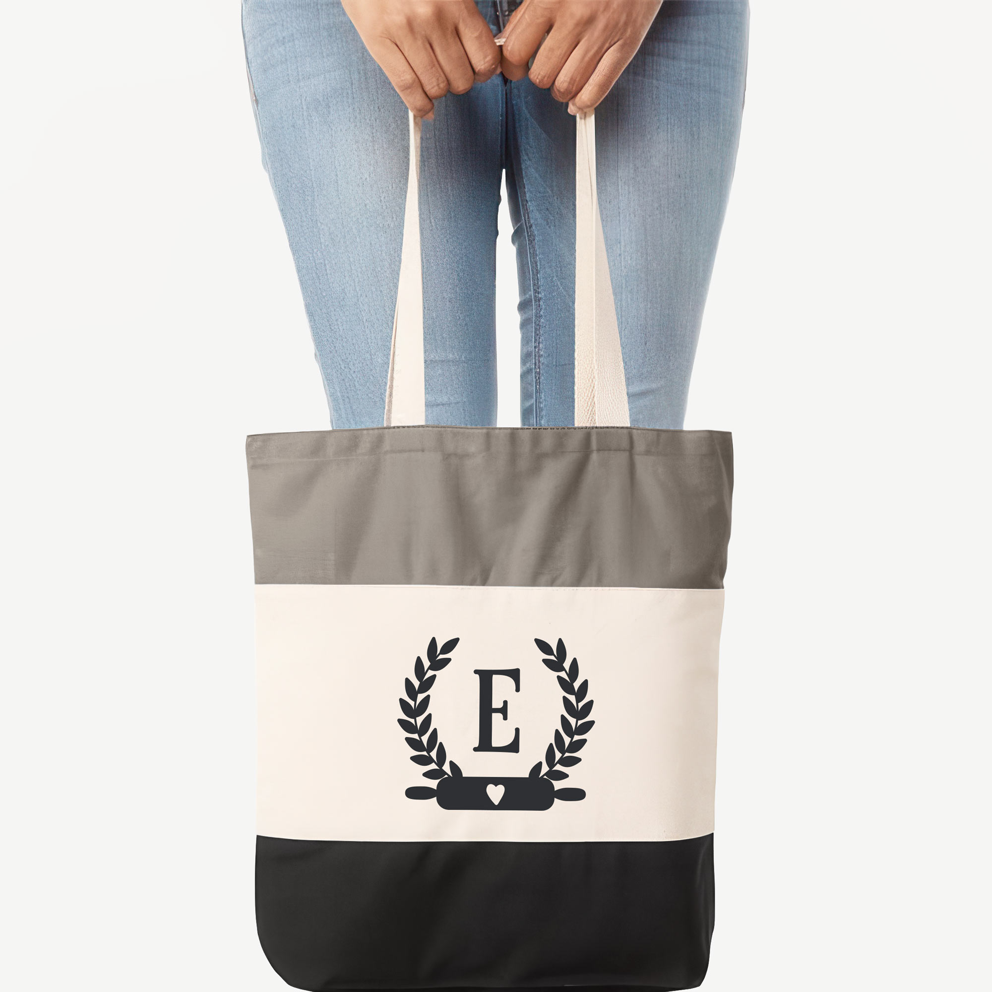 a woman holding a Monogrammed Baker Tote in black
