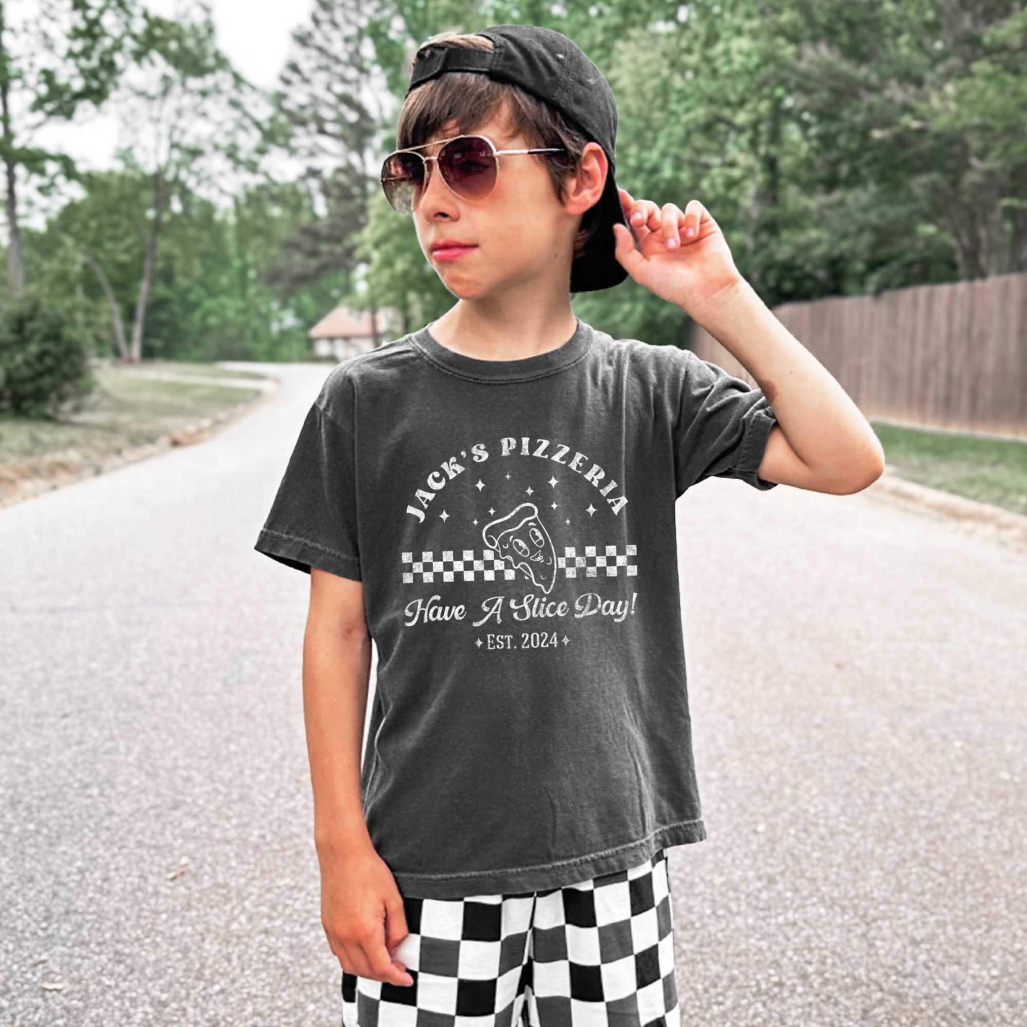 a young boy wearing a Personalized Kids Retro Pizza Shirt in pepper