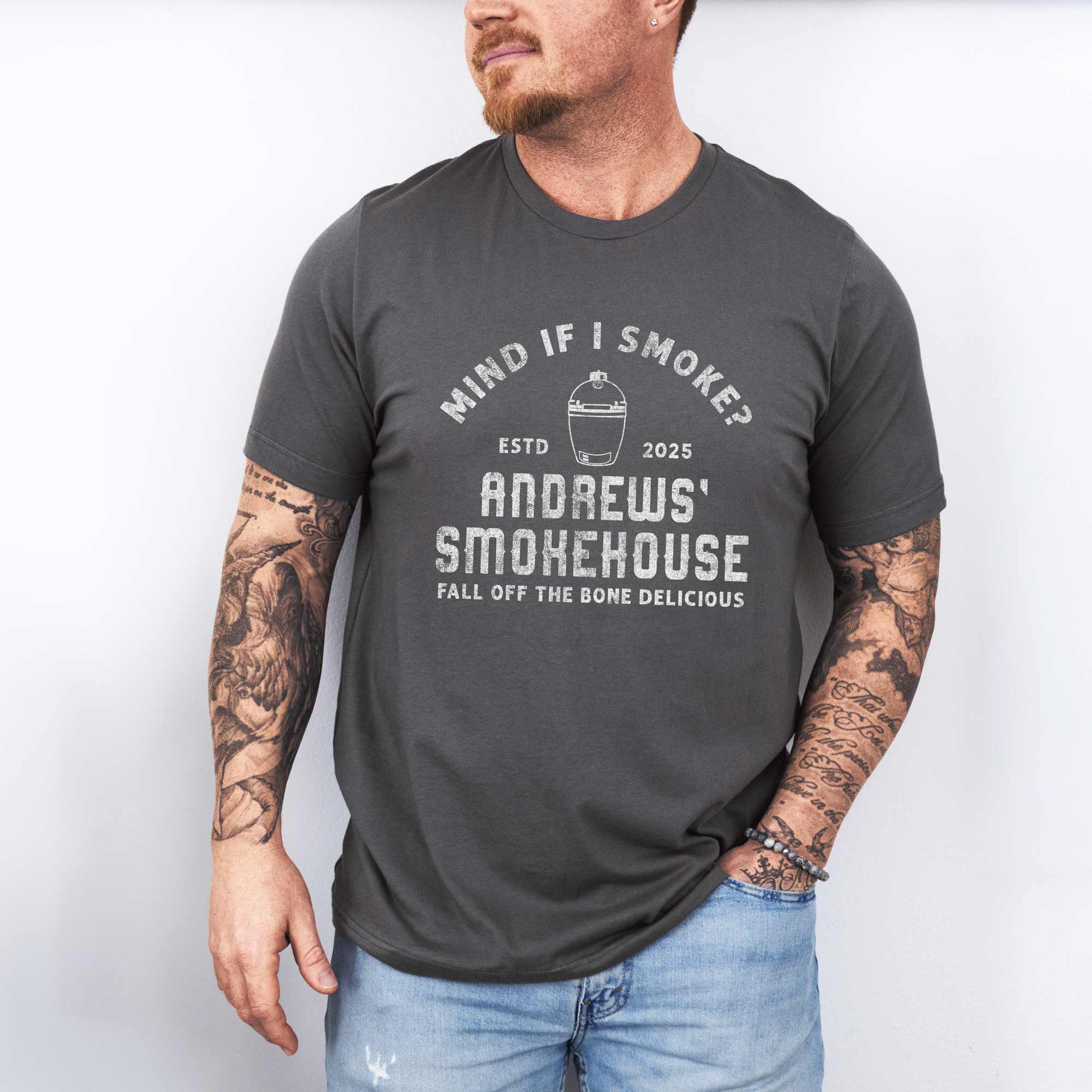 a man wearing a Personalized Meat Smoker T-Shirt in asphalt