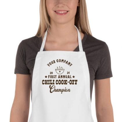 a woman wearing a custom butcher western chili cook off winner apron in white
