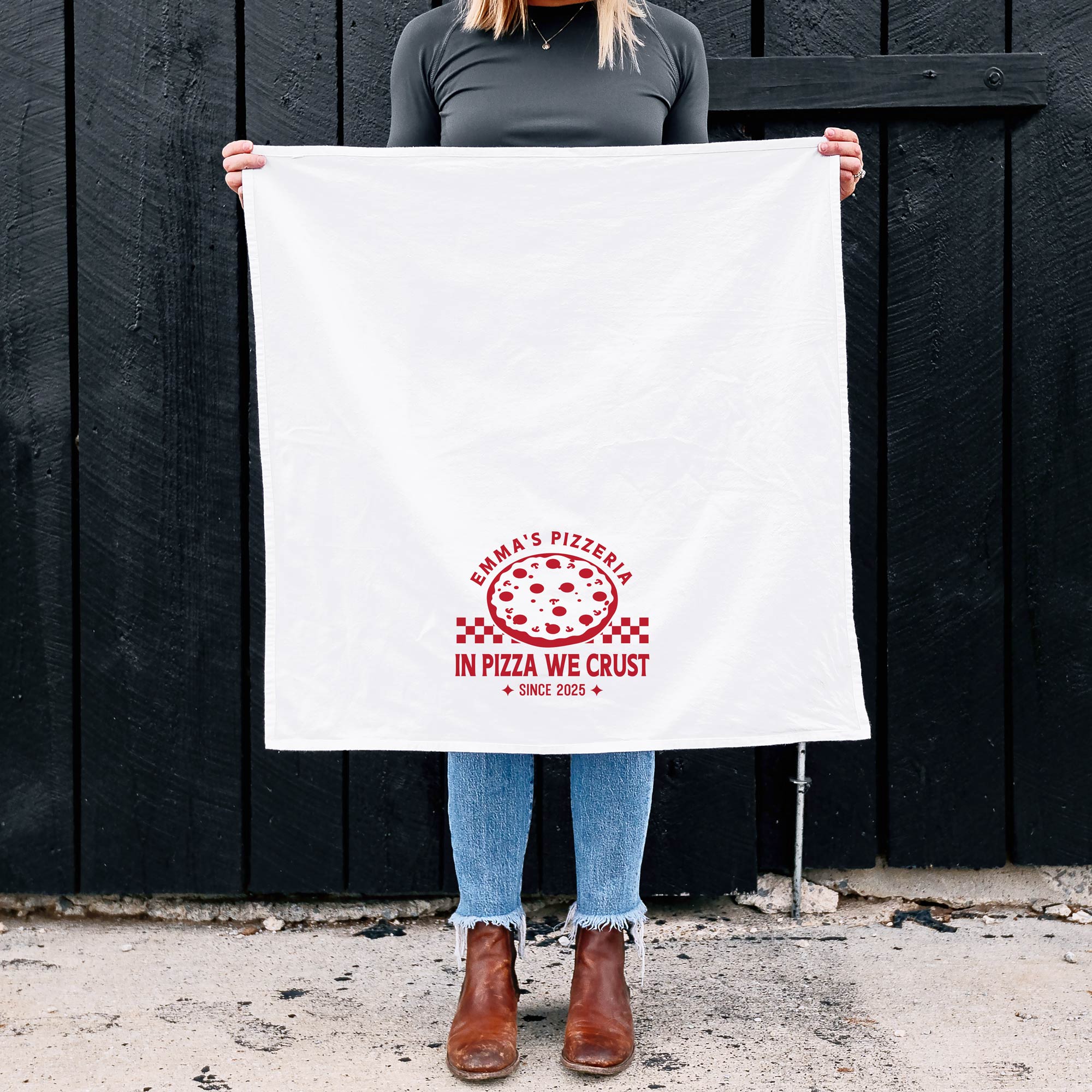 a woman holding up, out in front of herself, a personalized Checkered Pizza Tea Towel in white