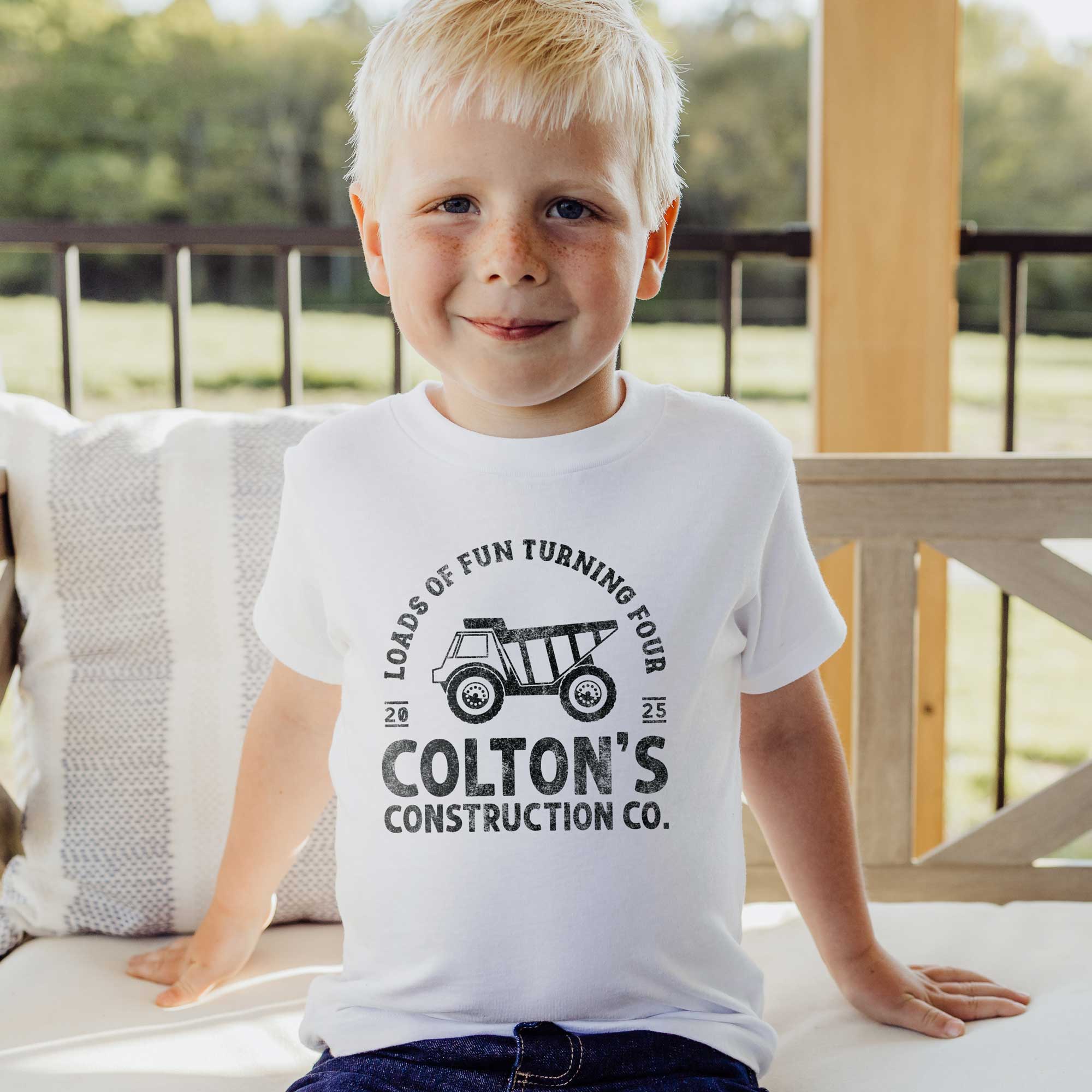 a little boy wearing a Birthday Construction Shirt: Dump Truck theme, in white
