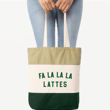 a woman holding a a Fa La La La Lattes Tote in forest green