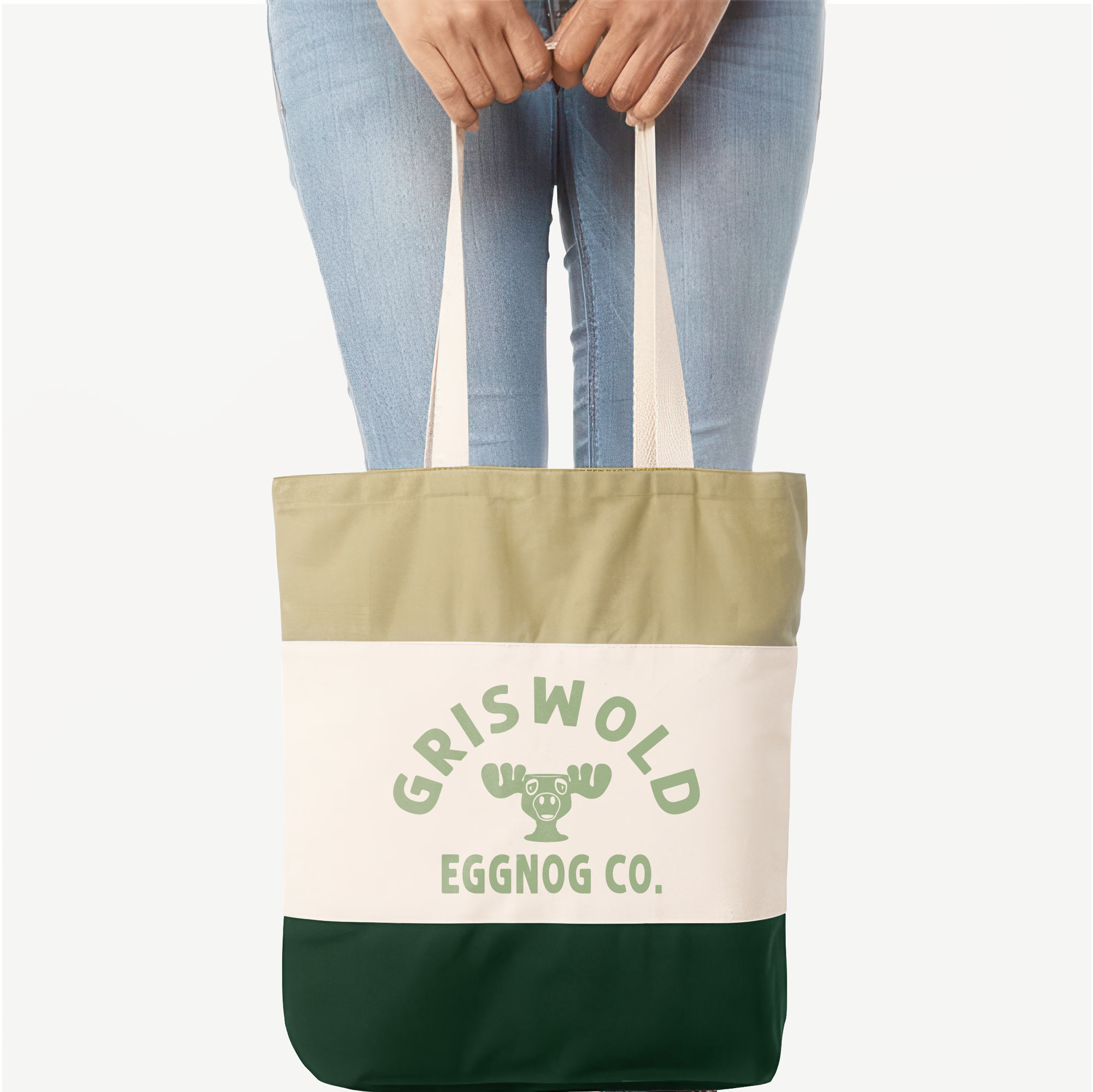 a woman holding a Griswold Eggnog Co. Tote bag in Forest green