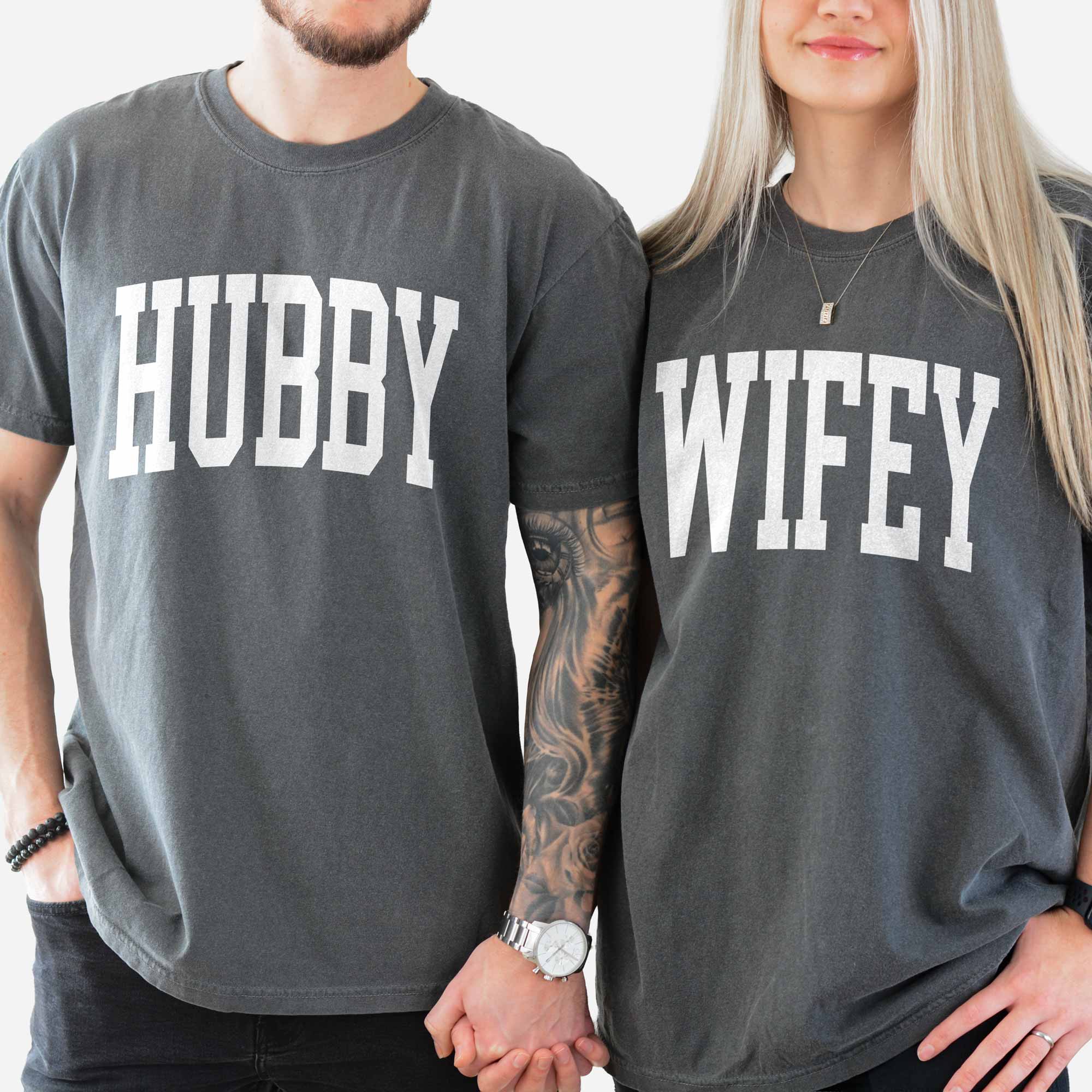 a man and a woman holding hands, wearing matching hubby wifey garment dyed tees in pepper
