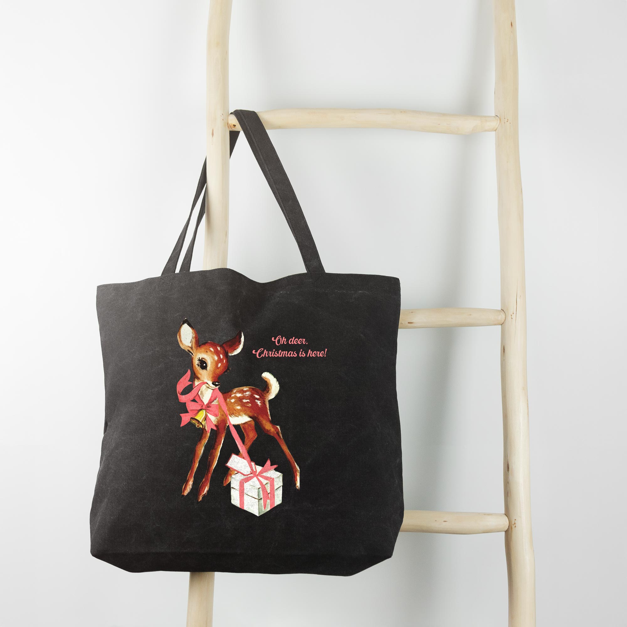 a Retro Deer Tote in washed black, hanging on a wooden ladder