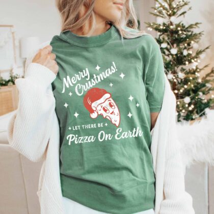 a young woman in a christmas scene, wearing a Retro Pizza Christmas T-Shirt in light green