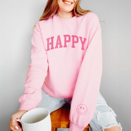 a young woman wearing an oversized Happy Smiley Sweatshirt in light pink