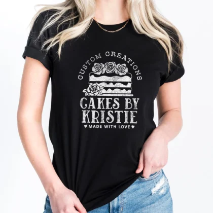 A woman wearing a Personalized Cake Baker Shirt in black with a white cake graphic