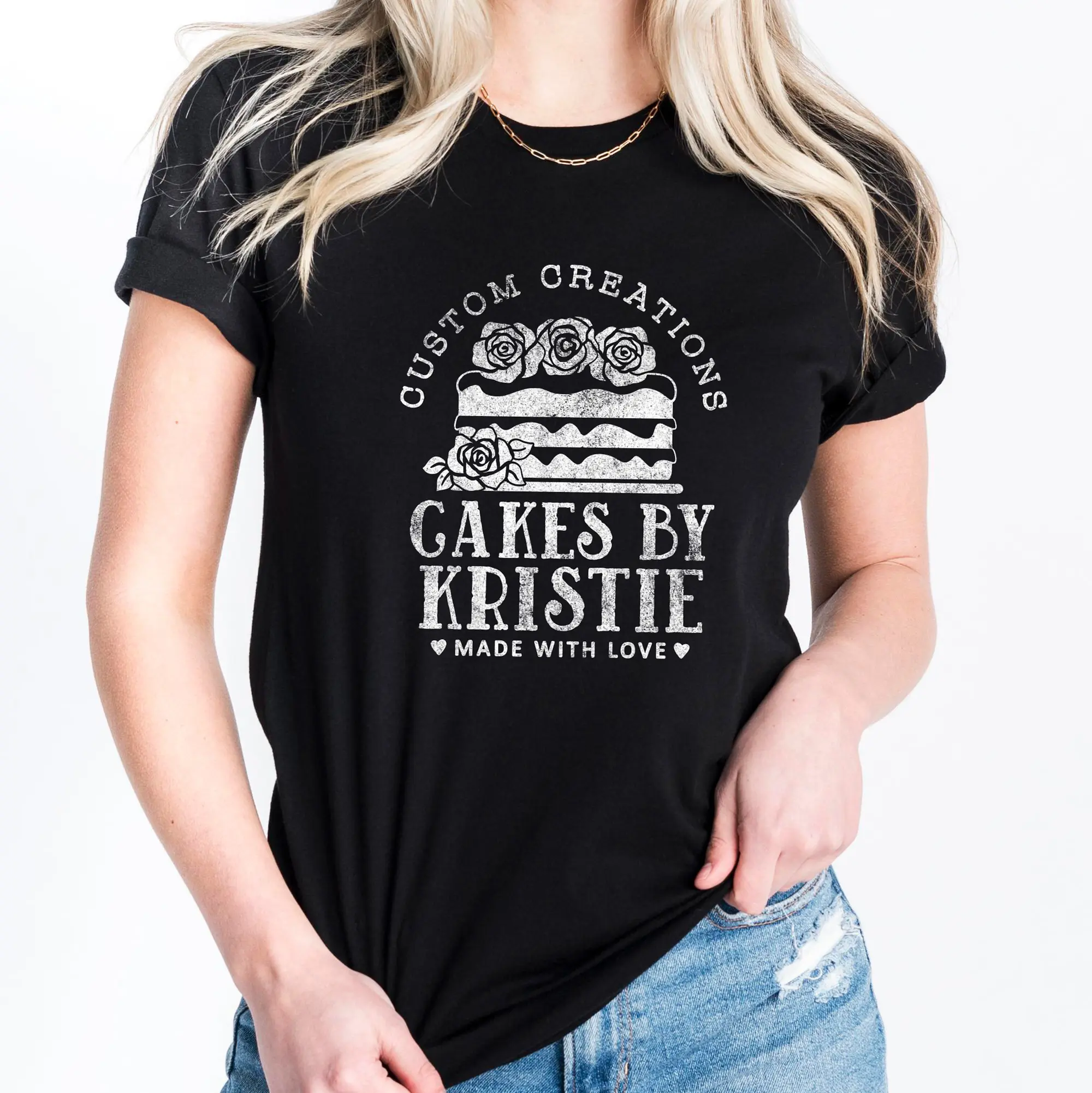 A woman wearing a Personalized Cake Baker Shirt in black with a white cake graphic
