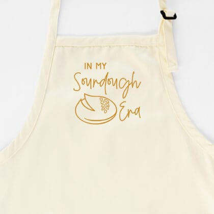 an In My Sourdough Era Apron in natural