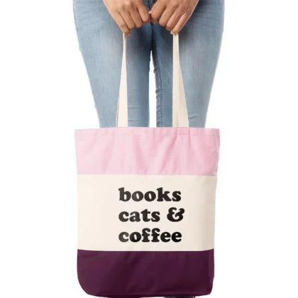 a woman holding A books cats coffee tote in pink