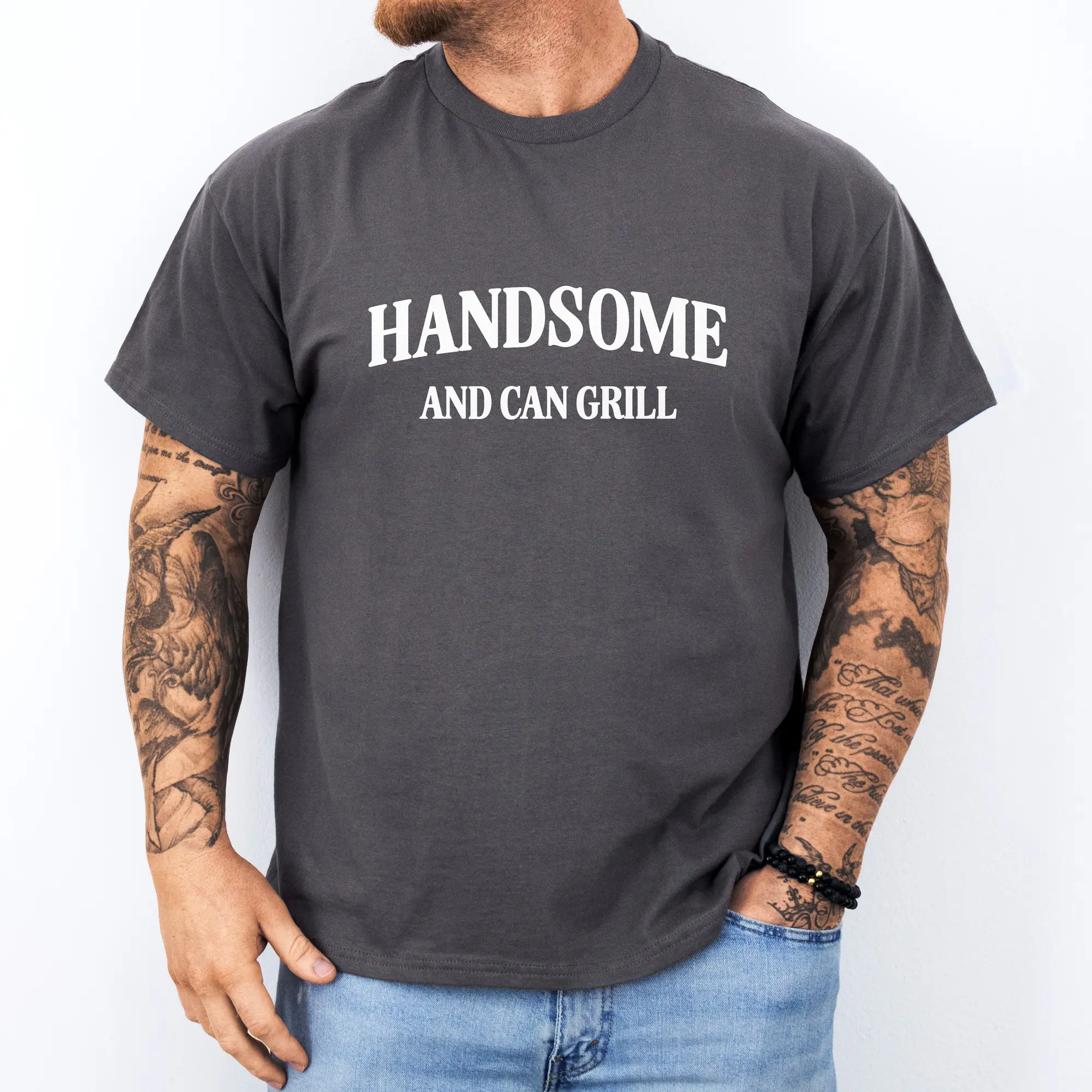a man wearing a handsome and can grill shirt in charcoal