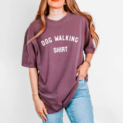 a woman wearing a dog walking shirt in berry