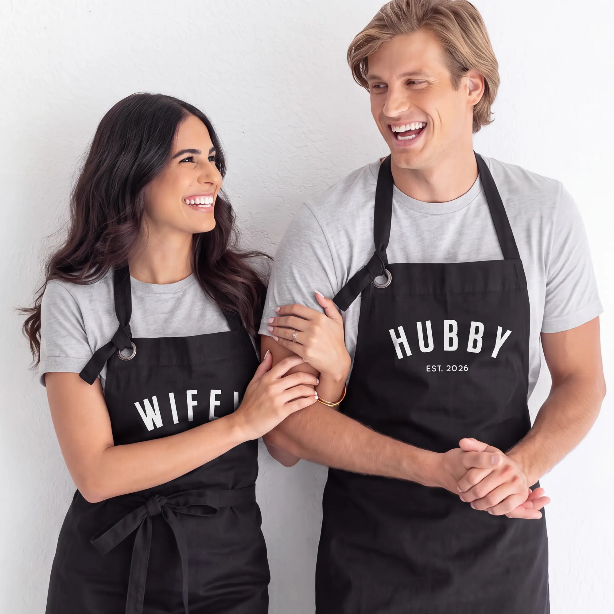 Couple wearing personalized black Hubby and Wifey aprons