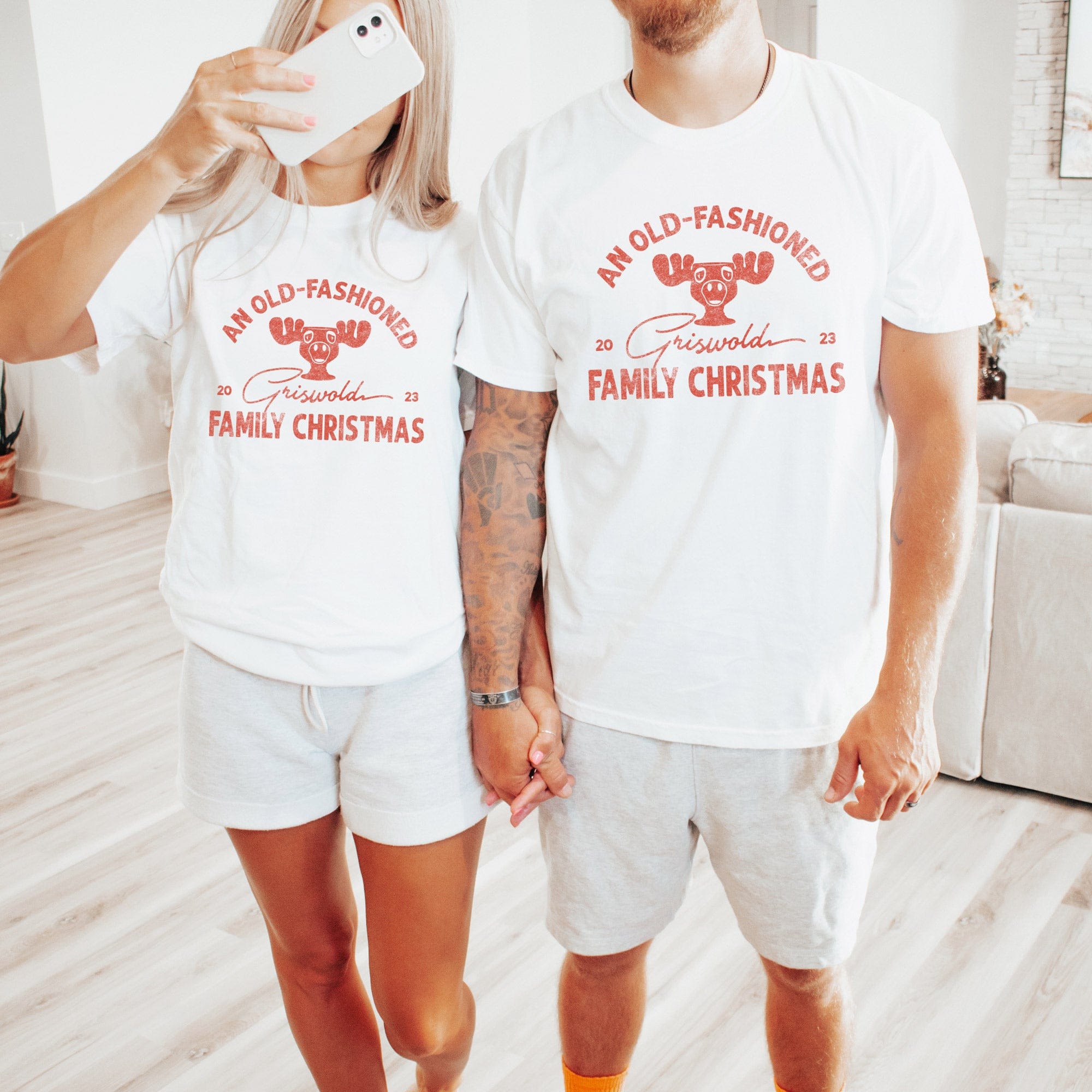 A young woman in a festive holiday scene, wearing an old-fashioned Griswold family Christmas T-shirt