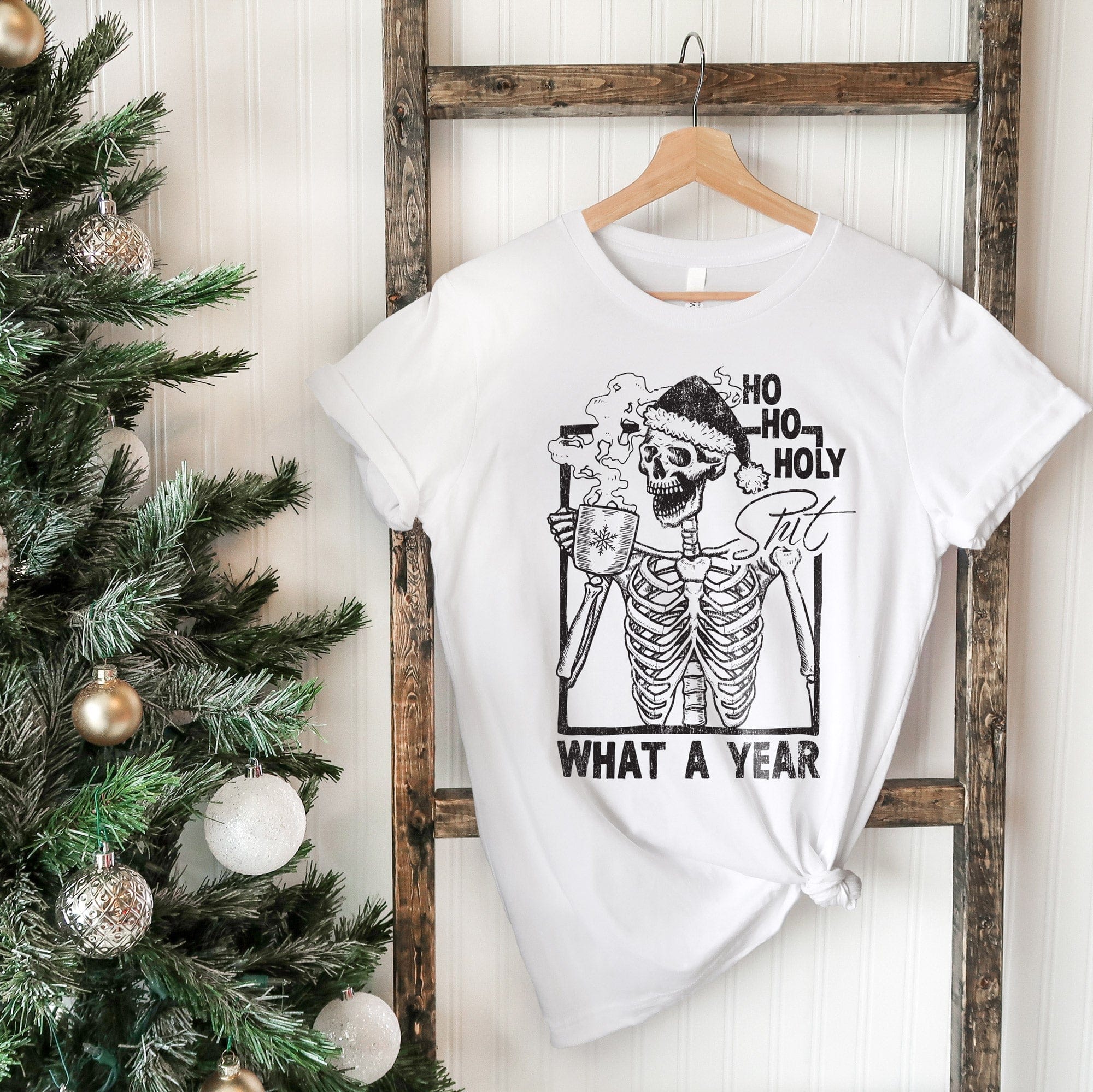 a Skeleton Xmas Shirt hanging on a ladder, next to a Christmas tree