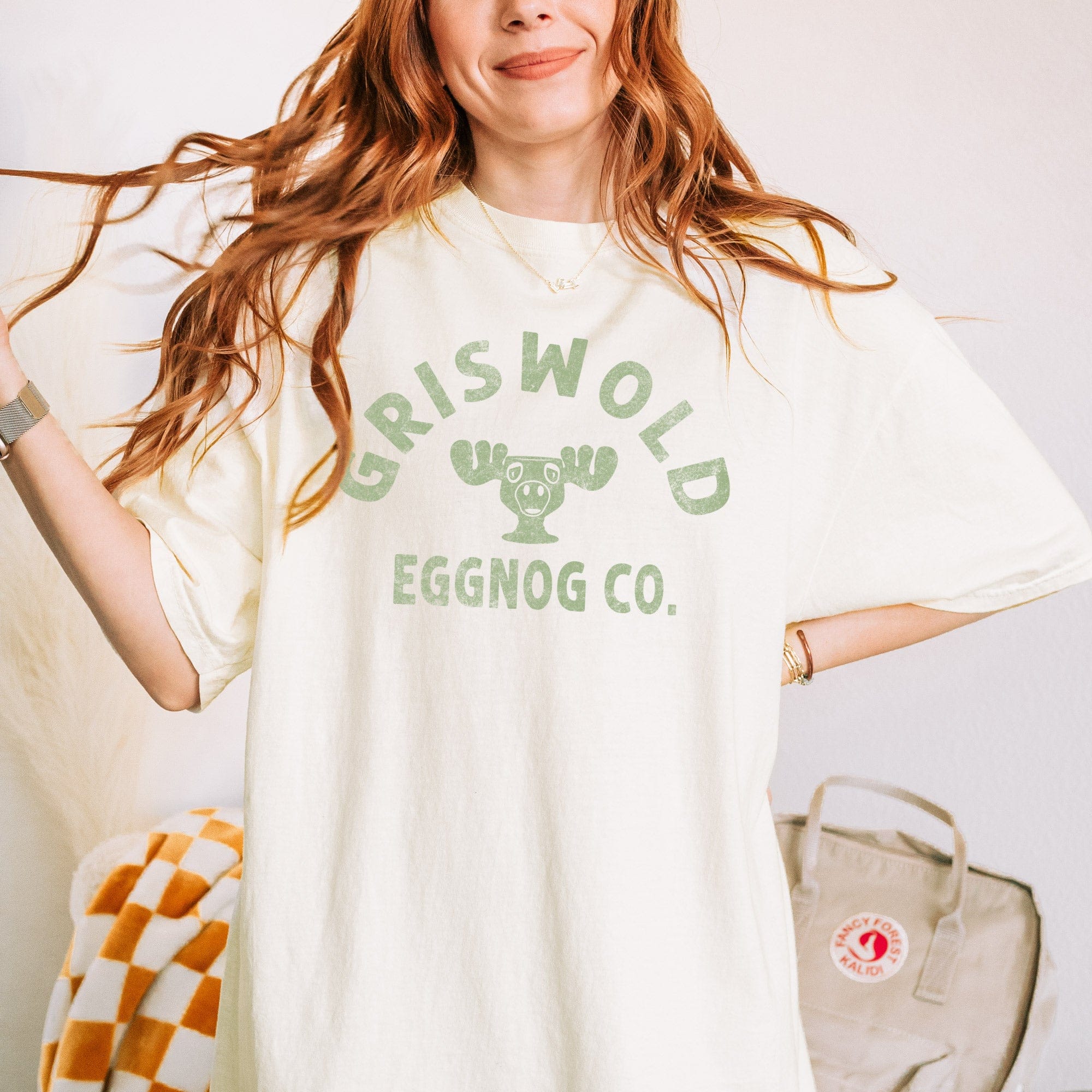 a young woman wearing a Griswold Eggnog Co. T-Shirt in ivory