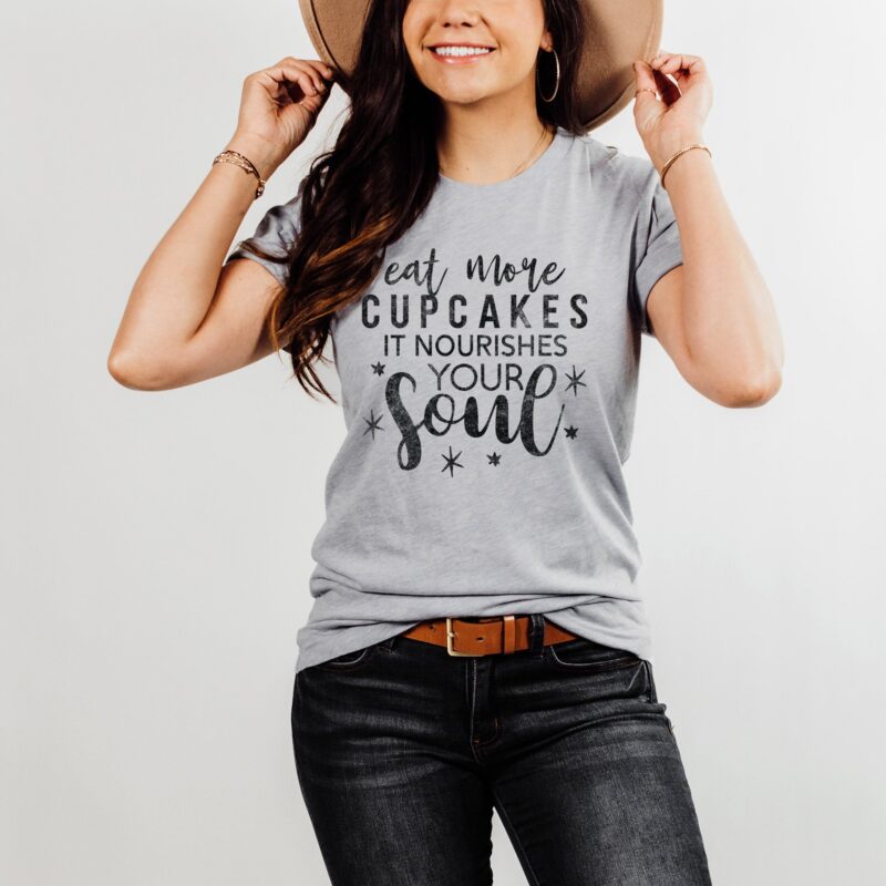 a happy young woman wearing a Eat More Cupcakes T-Shirt in athletic heather